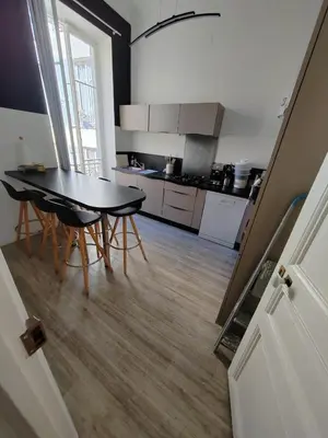 a kitchen with a table and chairs in a room at très grande chambre climatisée plein centre Nice avec balcon in Nice