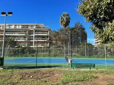 a tennis court in front of a building at Nice Seaside Appartement with Pool and Tennis in Saint-Laurent-du-Var