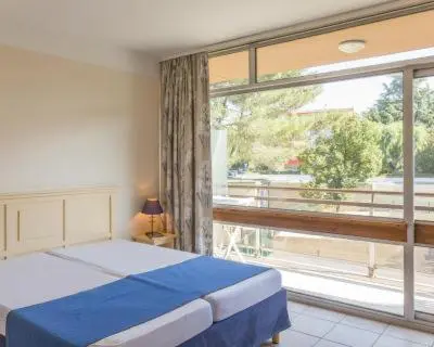 a bedroom with a bed and a large window at Nice Seaside Appartement with Pool and Tennis in Saint-Laurent-du-Var