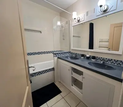 a bathroom with two sinks and a tub and a mirror at Nice Seaside Appartement with Pool and Tennis in Saint-Laurent-du-Var