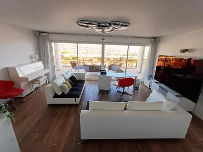 a living room with white couches and a piano at Penthouse - Vue mer panoramique - SPA privé - Piscine commune in Saint-Laurent-du-Var
