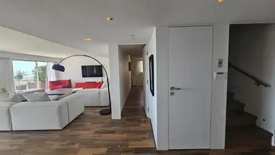 a living room with a white couch and a mirror at Penthouse - Vue mer panoramique - SPA privé - Piscine commune in Saint-Laurent-du-Var