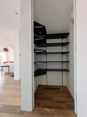 a room with a closet with black shelves at Penthouse - Vue mer panoramique - SPA privé - Piscine commune in Saint-Laurent-du-Var