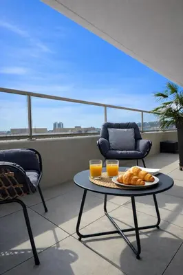 a table with a plate of bread and two glasses of orange juice at Luxury apartment with balcony & rooftop in Nice