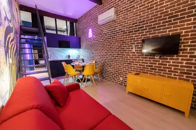 a living room with a red couch and a brick wall at Loft de 6 couchages, bord de mer à Nice in Nice