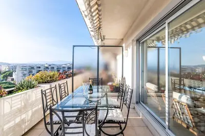 a glass table and chairs on a balcony with a view at 2BR Sea View Apartment with Pool & AC in Cagnes-sur-Mer