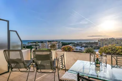 a patio with a glass table and chairs on a balcony at 2BR Sea View Apartment with Pool & AC in Cagnes-sur-Mer