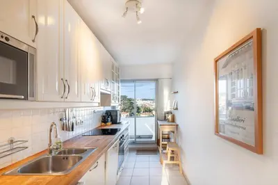 a kitchen with a sink and a large window at 2BR Sea View Apartment with Pool & AC in Cagnes-sur-Mer