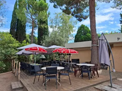 a wooden deck with tables and chairs and umbrellas at Heaven Nice in Nice