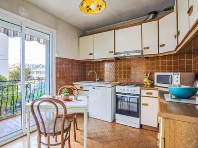 a kitchen with white appliances and a table with chairs at Holiday Home Maison Valensole by Interhome in Cagnes-sur-Mer