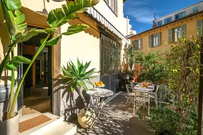 an outdoor patio with a table and chairs and plants at Maison Nice - Plage 300m - Parking in Nice