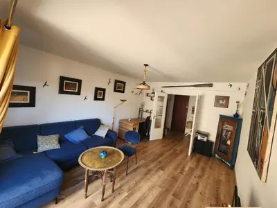 a living room with a blue couch and a table at Charmant 2 pièces in Nice
