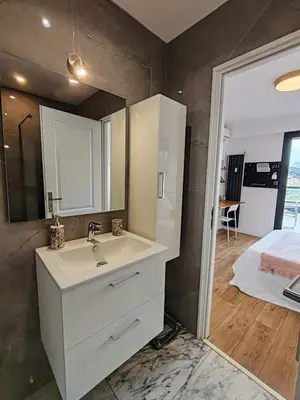 a living room with a mirror and a tv at Entre mer et montagne - Rooftop panoramique in Saint-Laurent-du-Var