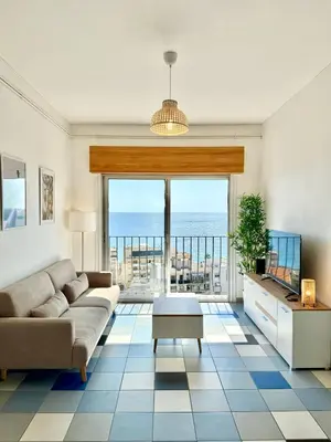 a living room with a couch and a view of the ocean at Vue mer panoramique, plage et Promenade à pied in Nice