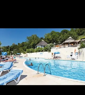 a swimming pool with chairs and people in the water at Mobilhome Camping 4 étoiles in Cagnes-sur-Mer
