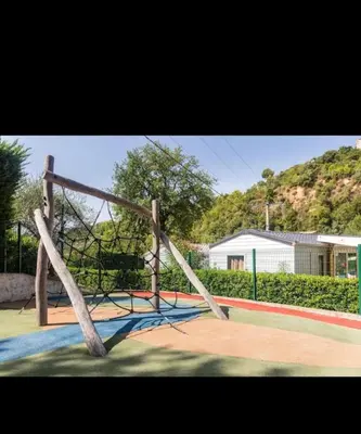 a swing set in a playground with a house at Mobilhome Camping 4 étoiles in Cagnes-sur-Mer