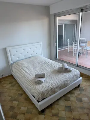 a bed in a room with a large window at Appartement 3 chambres avec piscine et parking privé in Nice