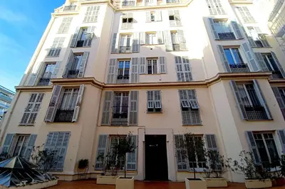 a tall white building with windows and a door at Large bright apartment in the heart of Nice in Nice