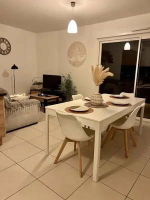 a living room with a white table and chairs at Appartement calme proche Nice à 20 min des plages in Colomars