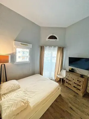 a kitchen with white cabinets and a black oven at Duplex close to the sea with parking in Nice