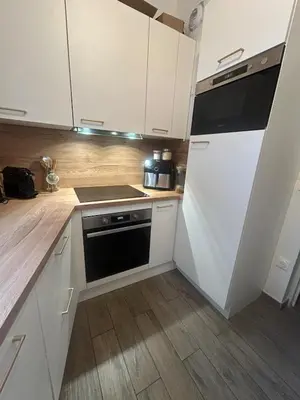 a small balcony with a table and a chair at Duplex close to the sea with parking in Nice