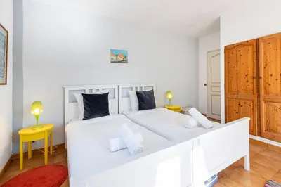 a white bed in a white room with two lamps at Villa in Cagnes-sur-Mer in Cagnes-sur-Mer