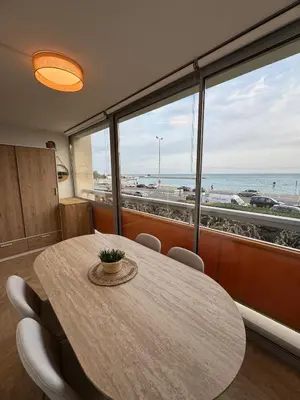 a dining room with a table and a view of the beach at Le California front de mer in Cagnes-sur-Mer