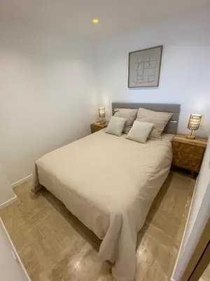 a bedroom with a large white bed with two lamps at Le California front de mer in Cagnes-sur-Mer
