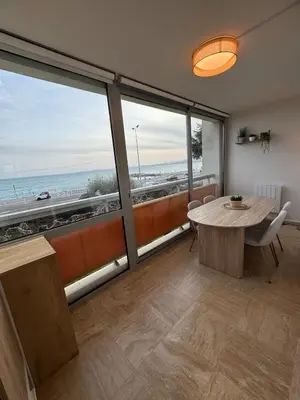 a room with a table and a view of the ocean at Le California front de mer in Cagnes-sur-Mer