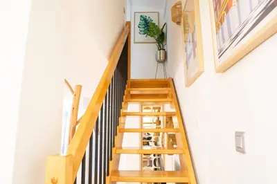 a wooden staircase in a home with white walls at Duplex carré d'or au calme sur cour 100m de la plage in Nice
