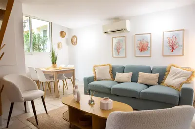 a living room with a blue couch and a table at Duplex carré d'or au calme sur cour 100m de la plage in Nice