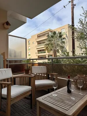 a patio with two chairs and a table with wine glasses at Charmant Studio Proche Plage et Transport in Saint-Laurent-du-Var
