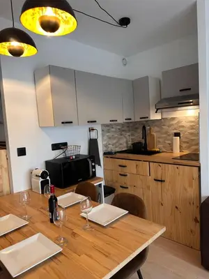 a kitchen with a wooden table with wine glasses at Charmant Studio Proche Plage et Transport in Saint-Laurent-du-Var