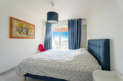 a bedroom with a bed and a window at Le Concorde in Saint-Laurent-du-Var