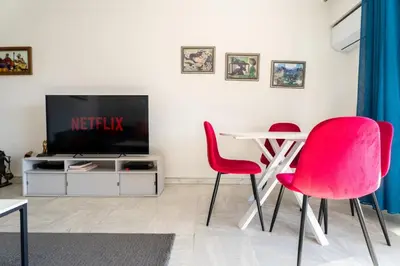 a living room with a table and two red chairs at Le Concorde in Saint-Laurent-du-Var