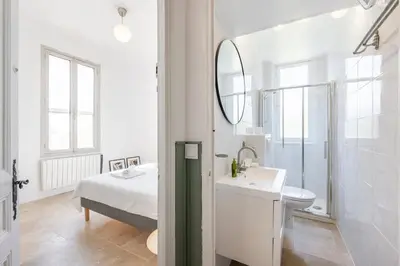 a white bathroom with a sink and a mirror at House on the Hill in Nice
