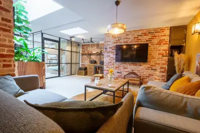 a living room with couches and a brick wall at Loft proche du port de Nice - 6 pers - Parking in Nice