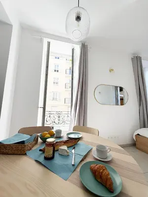a table with a plate of food on top of it at Lympia Riviera Residence in Nice
