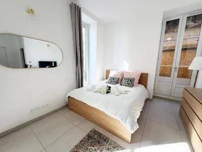 a bedroom with a bed with a mirror on the wall at Lympia Riviera Residence in Nice