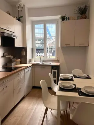 a kitchen with white cabinets and a table and chairs at Moderne 3 chambres, 2 douches, proche gare, wifi in Nice