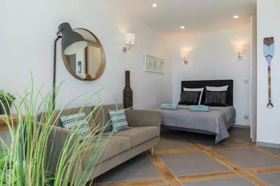 a living room with a couch and a mirror at La Maison Du Pêcheur in Cagnes-sur-Mer