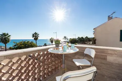a table and chairs on a balcony with a view of the ocean at La Maison Du Pêcheur in Cagnes-sur-Mer