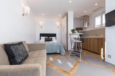 a living room with a couch and a kitchen at La Maison Du Pêcheur in Cagnes-sur-Mer