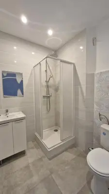 a white bathroom with a shower and a toilet at Chateauneuf in Nice