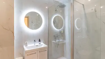 a bathroom with a shower and a sink and a mirror at B G Cocon Meyerbeer 2 - Grimaldi Promenade des Ang in Nice