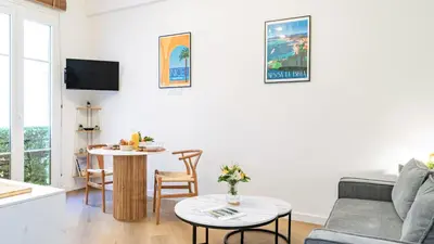 a living room with a couch and a table at B G Cocon Meyerbeer 2 - Grimaldi Promenade des Ang in Nice