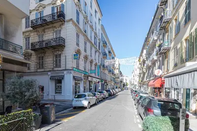 a city street with parked cars and buildings at B G Cocon Meyerbeer 2 - Grimaldi Promenade des Ang in Nice