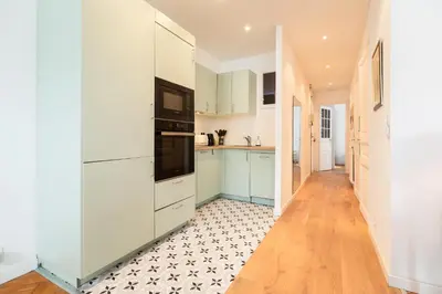 a kitchen with white cabinets and black appliances at Maison Bianchi - Durante - downtown in Nice