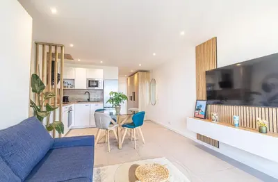 a living room with a blue couch and a table at Studio cosy Vue mer in Nice