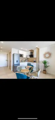 a kitchen with a table and some chairs in a room at Studio cosy Vue mer in Nice